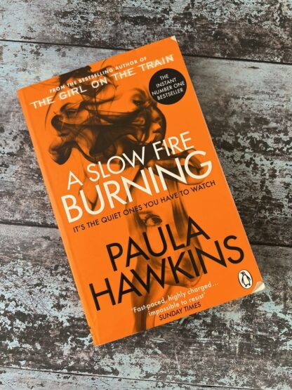 An image of a book by Paula Hawkins - A Slow Fire Burning